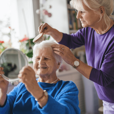 Pflegerin hilft beim Frisieren