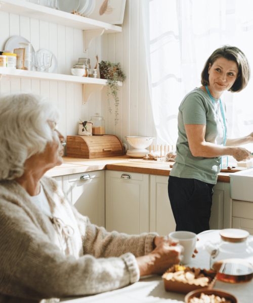 Pflegerin hilft alter Frau beim Kochen